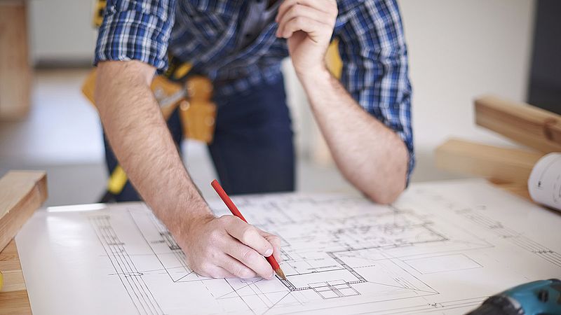 ein mann zeichnet einen bauplan