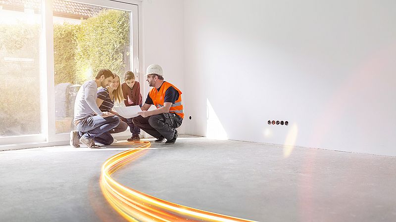 vier personen in hocke betrachten einen plan