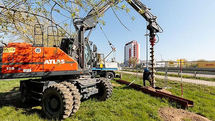 ein rotes großes baugerät auf einer grünen wiese